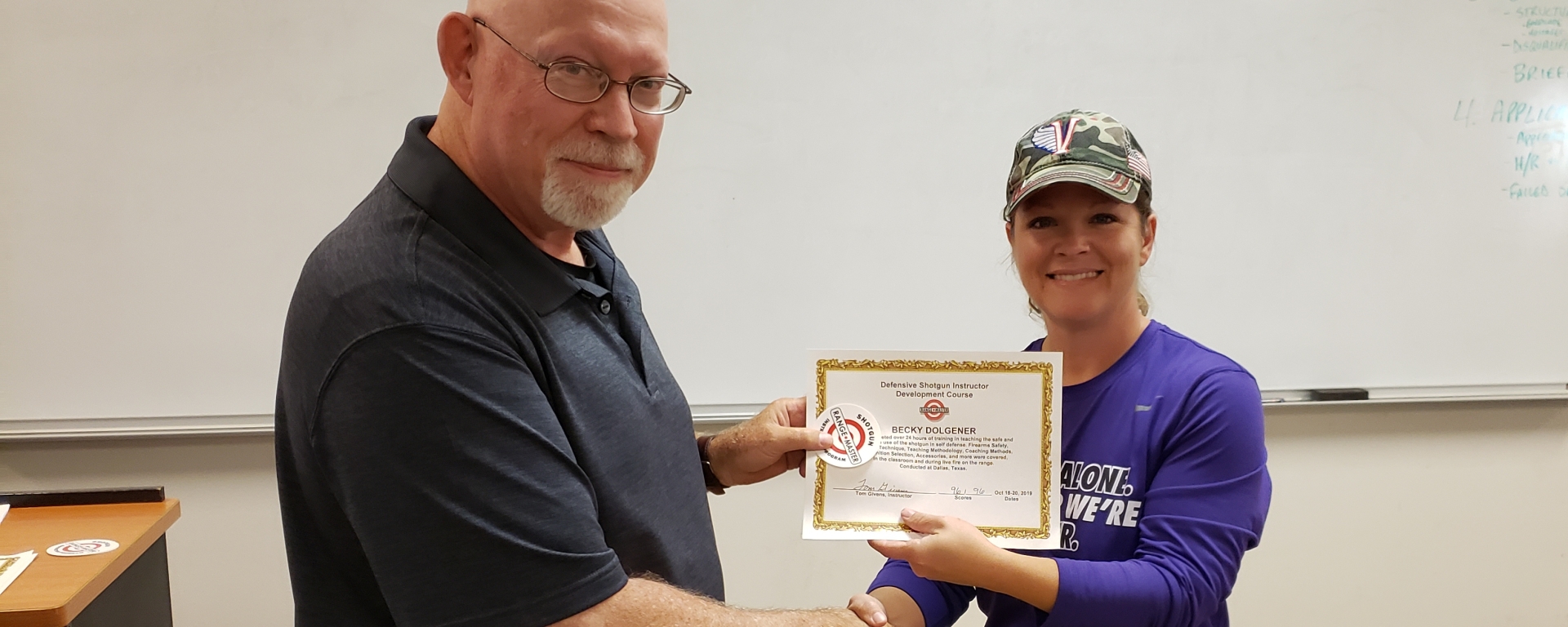 Becky receives a Rangemaster Defensive Shotgun Instructor certificate from Tom Givens